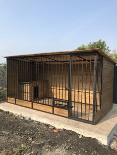 a dog kennel in the middle of some dirt