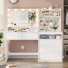 a white dresser with lights on it in a room next to a clock and potted plant