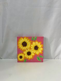 a pink box with yellow sunflowers painted on it