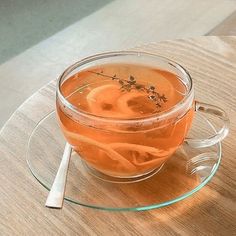 a glass cup filled with liquid on top of a wooden table