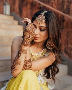 a woman with henna tattoos on her hands and arm is posing for the camera