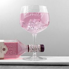 a pink wine glass next to a bottle on a white countertop with the word, empty