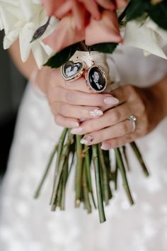 a bride holding her bouquet with two wedding rings on it