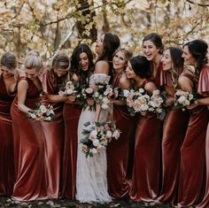 a group of women standing next to each other holding bouquets in their hands and laughing