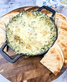 spinach dip in a cast iron skillet with pita bread