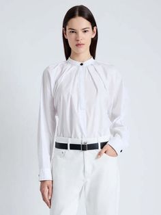 The carter top in tech poplin is cut to a relaxed silhouette with long sleeves. detailed with contrast topstitching a center front button closure and buttoned sleeve ends.    details    - white  - lightweight  - button neck closure  - long sleeve  - pleated detailing  - contrast topstitching  - buttoned sleeve ends  - relaxed finish  - 100% cotton  - proenza schouler white label (pswl)    size + fit    - model is 5'10'' with 31.5'' bust / 35'' hips. wearing size 4    care    - 100% cotton  - dry clean only      description tag  the carter top in tech poplin is cut to a relaxed silhouette with long sleeves. detailed with contrast topstitching a center front button closure and buttoned sleeve ends. Spring Long Sleeve Tops With Concealed Placket, White Tops With Concealed Placket For Fall, Classic Poplin Tops For Fall, Fall Daywear Tops With Concealed Placket, Classic Poplin Blouse For Fall, Chic Poplin Tops For Workwear, Fall Workwear Poplin Tops, Spring Workwear Poplin Tops, Spring Poplin Tops For Workwear