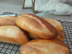 four loaves of bread sitting on top of a cooling rack