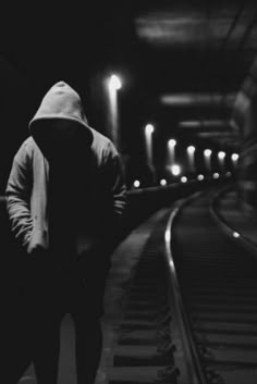 a person walking down a train track at night