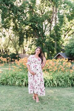 Remain a blooming vision in our Catalina Dress. This lovely dress features a hard-to-miss pink floral print that will remind you to stop and smell the roses. The full-length tiered skirt and half sleeves provide modest coverage for formal occasions. Meanwhile, the stretchy, elastic waistband grants bump-friendly comfort. Pair it with high heels for a look that will make your heart skip a beat. STYLE INFO & CARE Tiered Skirt Fully lined 100% polyester Maternity friendly style Machine Washable in Flowy Rose Print Maxi Dress, Pink Rose Print Maxi Dress For Garden Party, Feminine Flowy Floral Dress With Short Sleeves, Short Sleeve Floral Dress With Rose Print For Spring, Modest Short Sleeve Dress For Garden Party, Modest Short Sleeve Floral Dress For Spring, Feminine Short Sleeve Maxi Dress For Garden Party, Maternity Short Sleeve Maxi Dress For Spring, Spring Maternity Maxi Dress, Tiered