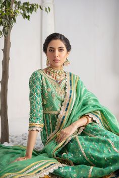 Make a colorful style statement with our beautifully crafted ensemble, gorgeous hand block printed kalidar, heavily embellished with sequins, beads and gota boti chan, neckline and sleeves are beautifully adorned with gorgeous zardozi work, stunning teal & Dhani green hued chata pati appliquéd border on hem finishes it beautifully, gorgeous detailed back and hand-made tassels gives entire outfit a trendy element. This stunning kalidar is offset with jamawar Lehanga and gorgeous Maysuri dupatta featuring gota motifs and heavily embellished chan, trimmed with gota borders , a Must- have wardrobe staple to carry all Wedding Festivities in effortless style. Kalidar Fabric: Pure Silk Net Lehanga Fabric: Jamawar Dupatta Fabric: Pure Maysuri Outfit Color: Opal This outfit is only available in Cus Pista Green Chanderi Palazzo Set With Mirror Work, Traditional Drape Mulmul Palazzo Set For Wedding, Designer Pista Green Palazzo Set With Gota Work, Traditional Sharara With Dabka Work In Cotton Silk, Traditional Chanderi Anarkali Set With Mirror Work, Festive Kundan Anarkali Set With Traditional Drape, Designer Chanderi Sharara With Resham Embroidery, Designer Traditional Wear With Mirror Work In Cotton Silk, Designer Green Cotton Silk Anarkali Set