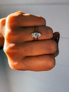 a woman's hand with a diamond ring on it