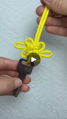 someone is tying a yellow rope with a pair of scissors to make it look like they are holding something