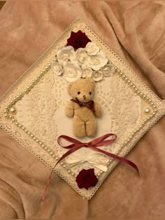 a teddy bear on a lace doily with roses