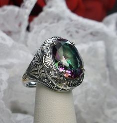 Simulated Rainbow Mystic Topaz Ring Description Lion Design#218 MADE TO ORDER I now offer this is a brand new Art Deco/Victorian reproduction ring in solid sterling silver. The gorgeous filigree ring is set with a simulated Mystic Topaz. The high quality round cut Mystic Topaz is 16mm by 12mm. The inside of the band is marked 925 for sterling. Notice the beautiful craftsmanship of the silver filigree setting. Feel free to ask questions and thanks for looking at my listings. All rings can be size Victorian Filigree, Art Deco Filigree, Wire Jewelry Rings, Mystic Topaz Ring, Victorian Ring, Antique Filigree, Order Design, Lion Design, Filigree Jewelry