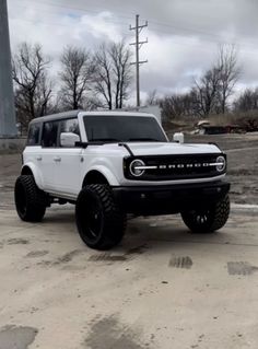 a white truck parked in a parking lot next to a light pole and power lines