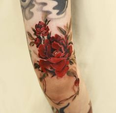 a woman's arm with red roses on it