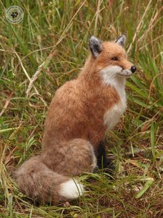 a stuffed fox sitting in the grass