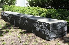 a stone bench sitting in the middle of a garden