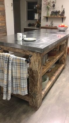 a kitchen island made out of pallet wood with two towels hanging on the rack