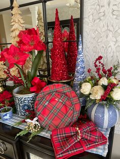 red and white christmas decorations on top of a dresser next to other holiday decor items