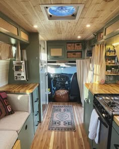 the interior of a small camper with wood floors and walls, including a kitchen