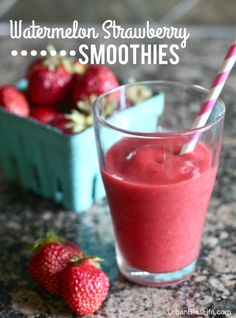 a glass filled with red liquid next to some strawberries