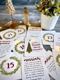 christmas cards with the names and numbers for each card in front of a potted plant