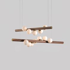 several lights hanging from the ceiling with wooden poles and white balls on top of them