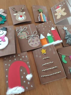 several christmas cards are laid out on a table with paper decorations and magnets attached to them