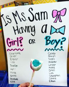 a sign that says it's ms sam having a girl or boy? and is holding a lollipop