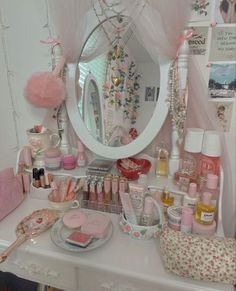 a vanity with pink accessories on it and a mirror in the corner, all around