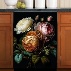 a painting of flowers on a dishwasher in a kitchen next to some apples