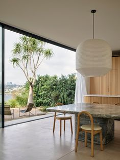 a table and chairs in a room with large windows