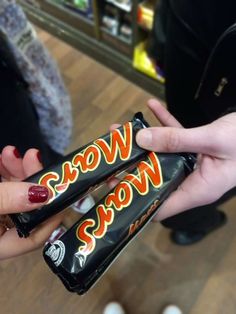 two people holding candy bars with the words wow snow on them in front of each other