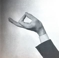 a black and white photo of a person's hand holding something in the air