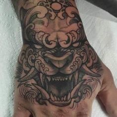 a man's hand with a tattoo on it and an animal head in the middle