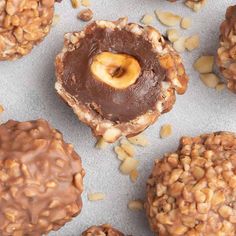 chocolate covered cookies with nuts and peanut butter in the middle on a sheet of wax paper