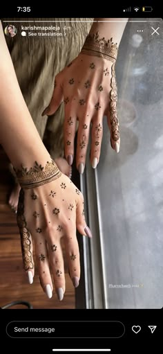 two hands with henna tattoos on them and one hand in the middle of the frame