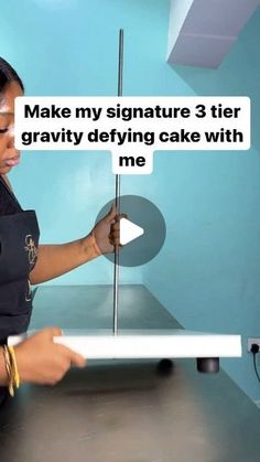 a woman is making a cake with the words make my signature 3 tier gravity defying cake with me