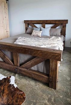 a bed made out of wooden planks in a room with cow hide rug on the floor