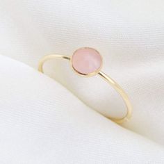 Our delicate Rose Quartz Ring features a pink natural gemstone in a gold filler or sterling silver setting! Rose Quartz is the birthstone for all our October-born babes. Don't know your ring size? Ring Size Guide or Buy Ring Sizer …………………………………. Details: Stone is Natural Rose Quartz, measuring 5mm Available in 14k Gold Filled or Sterling Silver Waterproof and can be worn everyday Size Inclusive and made to order About Your Jewelry If you are not wearing your jewelry it is best to store it in a c