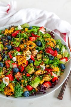 a white plate topped with a colorful salad