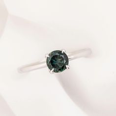 * One of a kind ring * In stock ready to ship in size 7 * 0.82ct Teal Blue Green Queensland Sapphire, 5.67x5.67x3.31mm, vvs, very clean with no visible inclusions even with a 10x magnification * Band width: approx. 1.6-1.8mm * High profile four prongs flower setting for easy stacking * Made of recycled solid 14k white gold and ethically sourced gemstones * Packaged in a recyclable kraft ivory ring box