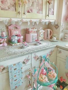 a kitchen filled with lots of pink and white decor on top of a counter next to a sink