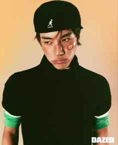 a young man wearing a black hat and green shirt with the word dazed on his forehead