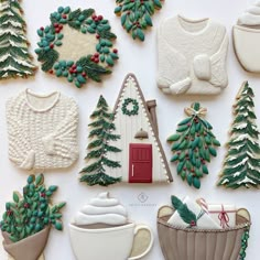 christmas cookies decorated like houses, trees and sweaters are displayed on a white surface