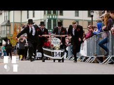 a group of men in suits and ties pulling a cart with a clock on it