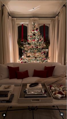 a living room with a christmas tree in the corner and presents on the coffee table