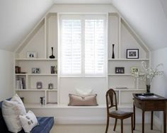 a room with white walls and shelves filled with books