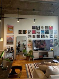 a living room filled with lots of furniture and pictures on the wall above it's flat screen tv